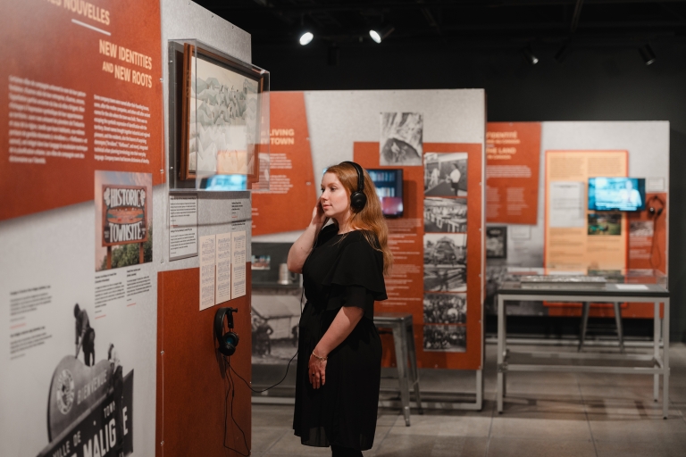 Visiteurs interagissant avec un module interactif de l’exposition sur les villes de compagnie à Valcourt